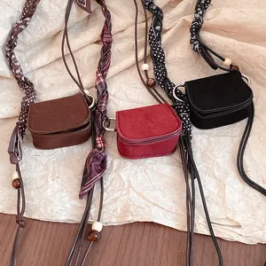 Detailed view of three vintage mini waist bags in brown, red, and black with braided straps.