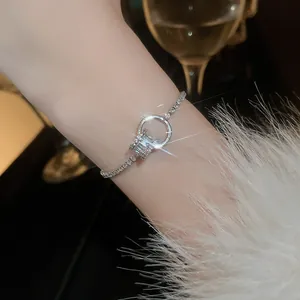 Close-up detail of a sparkling silver gold-plated bracelet with zircon stones on a wrist.