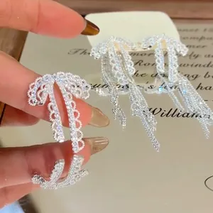 Dettaglio macro di orecchini a fiocco con strass e finitura argento brillante