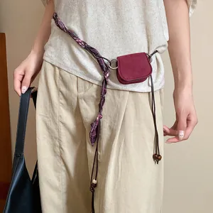 Detailed view of vintage burgundy pouch and braided scarf waist chain belt
