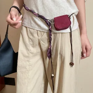 Detailed view of vintage burgundy mini waist bag with braided scarf chain and bead accents