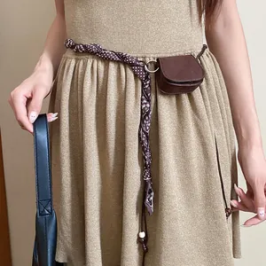 Detail shot of a retro brown mini pouch attached to a patterned fabric waist belt.