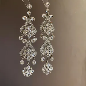 Detailed macro view of sparkling rhinestone tassel drop earrings in silver finish