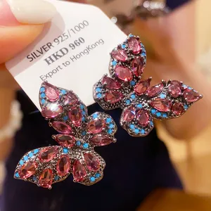 Detailed view of vintage butterfly earrings with pink crystals and silver 925 tag