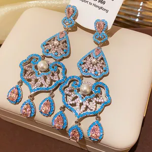 Detailed view of vintage chandelier earrings with pink stones, pearls and turquoise beads.