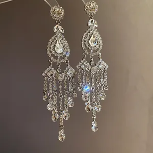 Detailed view of luxury chandelier earrings with rhinestones and drop crystal tassels.