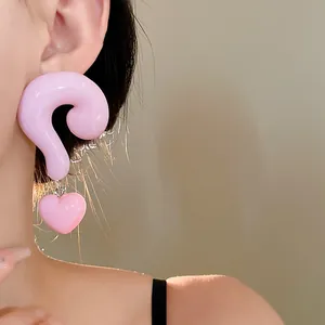 Close-up detail of a playful pink resin question mark earring with a heart charm.