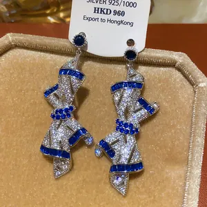 Detail view of luxurious ribbon-shaped earrings encrusted with blue and white crystals