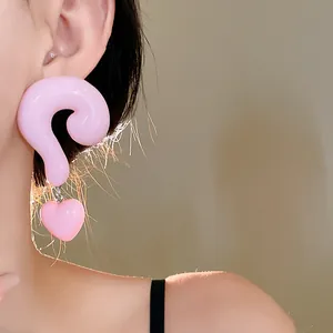 Close-up of pink resin question mark stud earrings with heart charms for women.