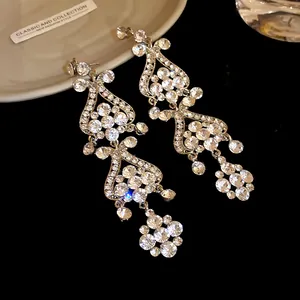 Close-up of elegant rhinestone tassel chandelier earrings with intricate sparkle detail.