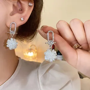 Nahaufnahme von eleganten silbernen Blumen-Ohrringen mit glitzerndem Strassbesatz