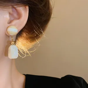 Detail view of vintage Maillard style irregular resin earrings on a model's ear lobe