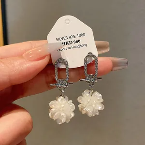 Nahaufnahme von eleganten silbernen Blumenohrringen mit funkelnden Strass-Akzenten