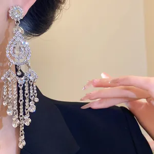 Close-up of elegant silver tassel earrings with water drop and rhombus crystal accents