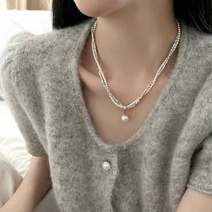 Detailopname van een elegante dubbellaagse ketting met zilveren kralen en parels