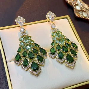 Detailed close-up of palace style earrings featuring green zircon tassels and gold setting