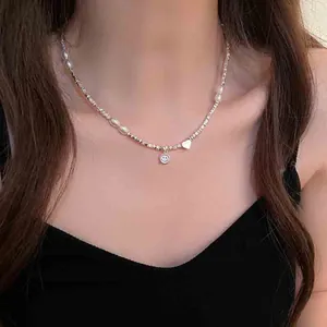 Detailopname van een elegante parel- en zilveren ketting met hart- en smiley-bedels