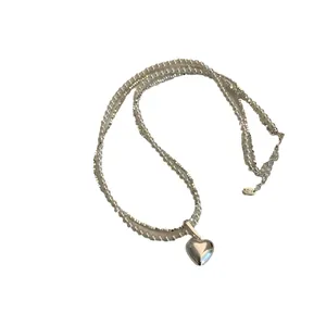 Elegante dubbellaagse ketting met witte parels, zilveren kralen en een hartvormige hanger