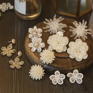 Collection of elegant vintage pearl and beaded flower earrings on a wooden display