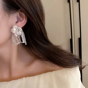 Elegant close-up view of retro pearl flower earrings with bead tassels worn by a model