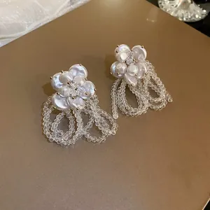 Close-up of elegant pearl flower earrings featuring clear crystal bead fringe tassels