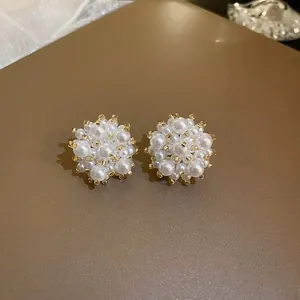 Macro shot of elegant pearl cluster flower stud earrings with intricate vintage design