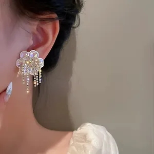 Close-up detail of elegant French vintage pearl flower earrings with dangling tassels