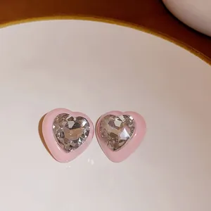 Detailed close-up showing pink heart-shaped earrings with a sparkling central gemstone