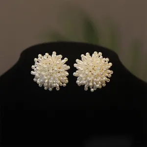 Detailed view of elegant cluster pearl flower earrings on a black jewelry display stand