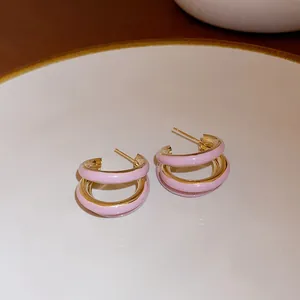 Detailed view of elegant pink enamel layered hoop earrings with a shiny golden finish