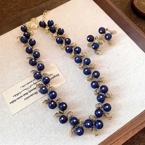 Elegant vintage blue resin bead necklace and earrings set with textured gold leaf accents