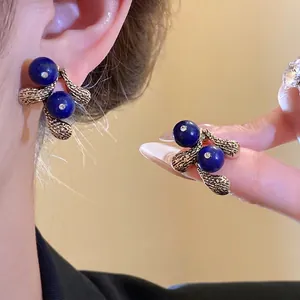 Vintage gold-tone earrings with deep blue resin beads in elegant retro jewelry style
