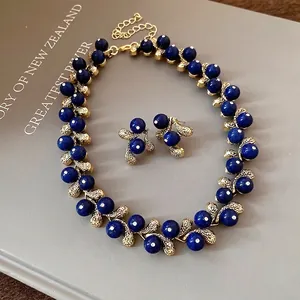 Elegant vintage jewelry set featuring blue resin beads and gold-tone leaf accents
