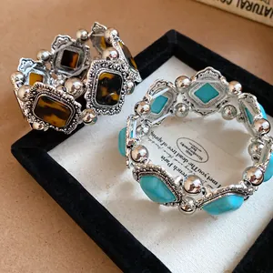 Detail view of Bohemian vintage elastic bracelets with turquoise and amber stones in a display box