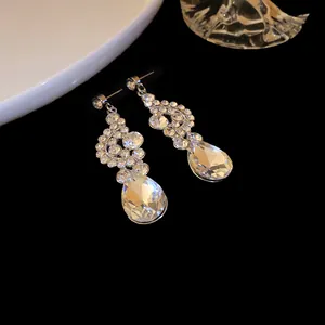 Dettaglio macro di eleganti orecchini a goccia d'argento con strass scintillanti.