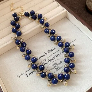 Detailed view of vintage navy blue resin bead necklace with intricate gold-tone metal links
