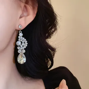 Primo piano di eleganti orecchini a ventaglio con strass e cristallo a goccia