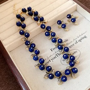 Close-up view of vintage blue resin bead necklace and earrings set in a jewelry box