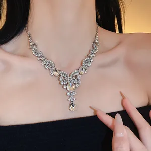 Dettaglio di una collana scintillante di strass con ventaglio e goccia sul collo.