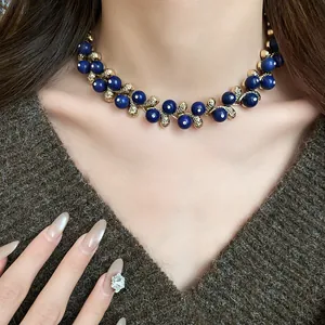 Close-up of vintage-style choker necklace with blue beads and golden leaf design
