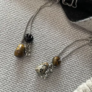 Detailed close-up showing natural tiger eye and dalmatian jasper waterdrop necklaces