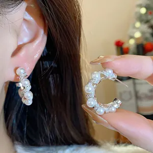Detailed view of French-style pearl and cubic zirconia earrings with 18k gold plating