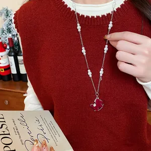 Detailed view of an elegant red flocked rocking horse necklace with white pearls