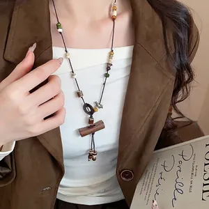 Bohemian ethnic long necklace with wooden beads and coconut shell pendant on model