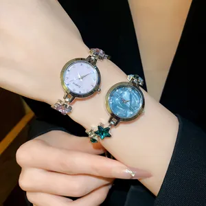 Close-up of elegant star bracelet watches with pink and blue quartz dials.