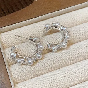 Detailed view of elegant silver-plated hoop earrings with pearls and sparkling cubic zirconia