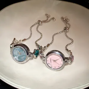 Detail view of elegant silver quartz watch bracelets with star charms in pink and blue dials