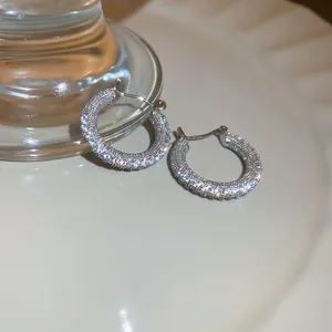 Primo piano di orecchini a cerchio vintage con pavé di zirconi bianchi scintillanti
