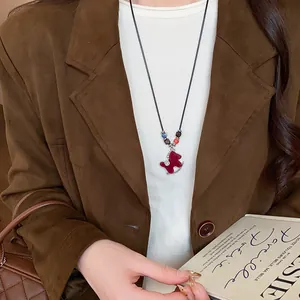 Detailed view of red flocked rocking horse necklace with colorful beads and zircons