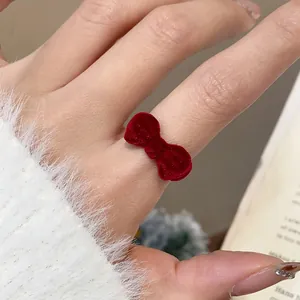 Nahaufnahme zeigt die Textur eines roten beflockten Vintage-Schleifenrings am Finger
